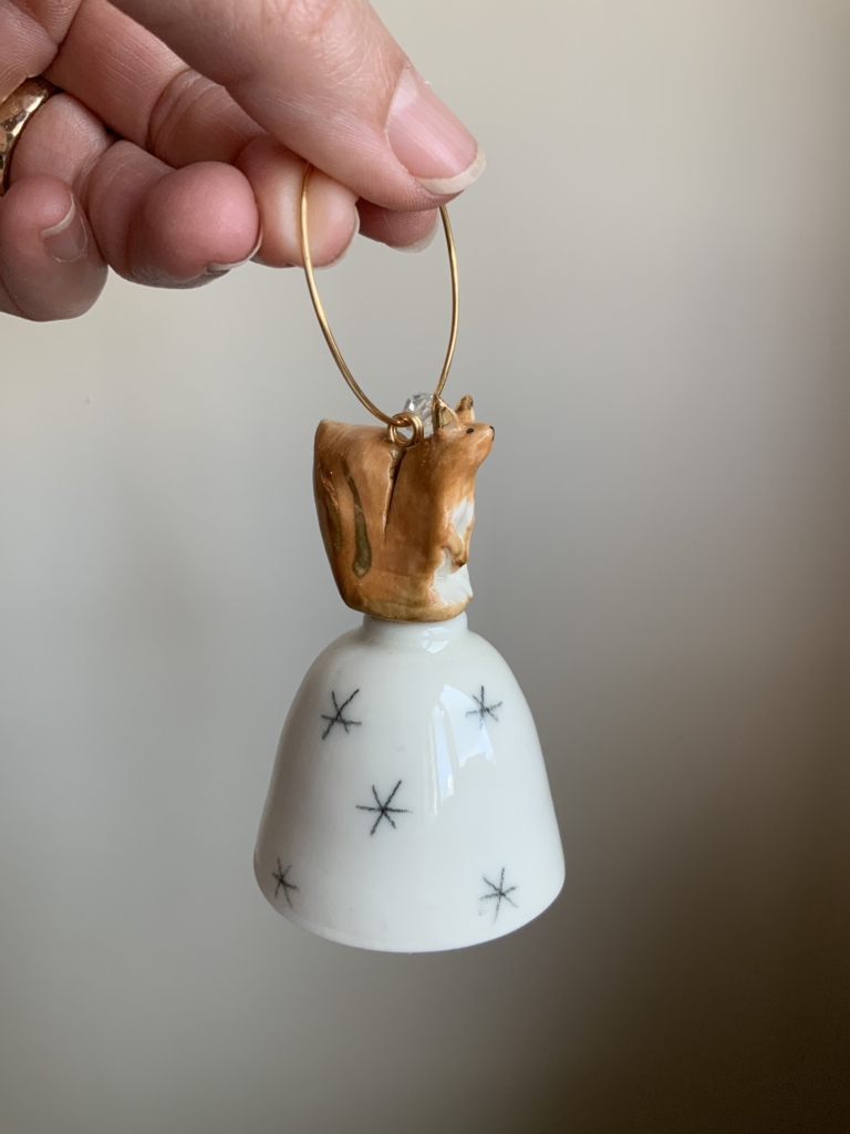 Christmas tree bell, with pencil snowflake design and topped with a handmade Squirrel with gold lustre.
