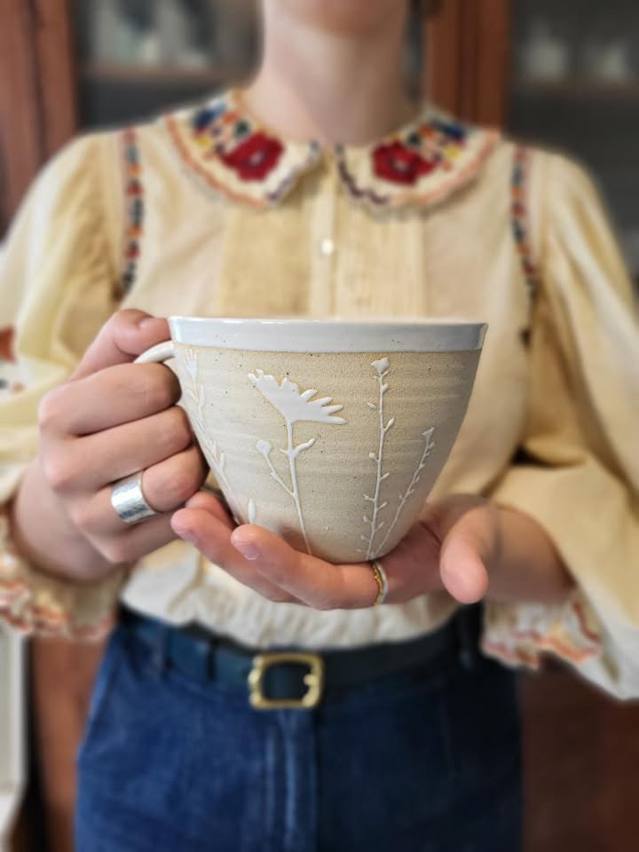 Stoneware cup with matt background and white glazed Leaf design