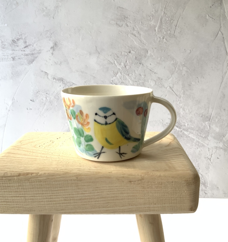 Porcelain cup with hand painted blue tit and botanical design