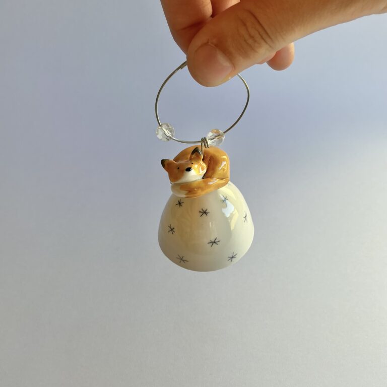 Christmas tree bell, porcelain with pencil star design and topped with a handmade sleeping fox.